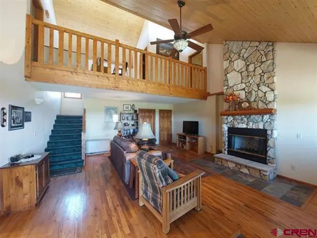 a living room with furniture a fireplace and a wooden floor