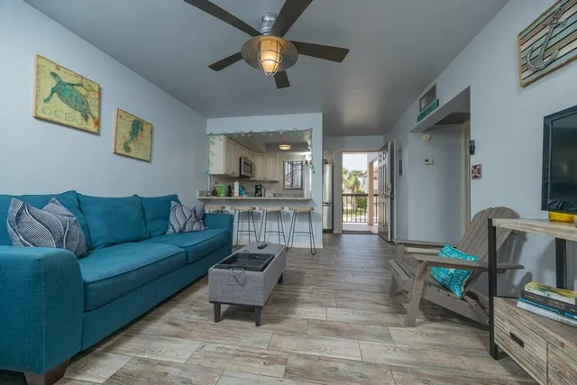 a living room with furniture and a view of kitchen