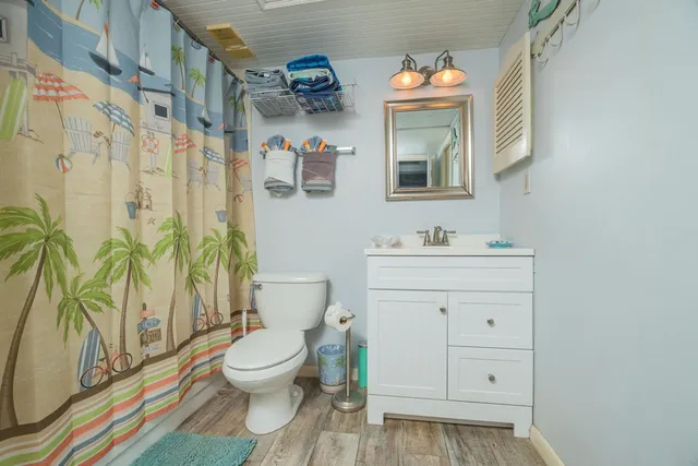 a bathroom with a granite countertop toilet sink and a mirror