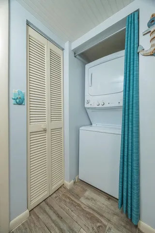 a utility room with wooden floor washer and dryer