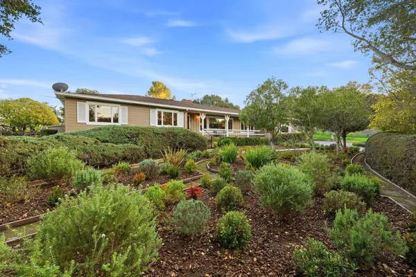 a front view of a house with a yard and trees