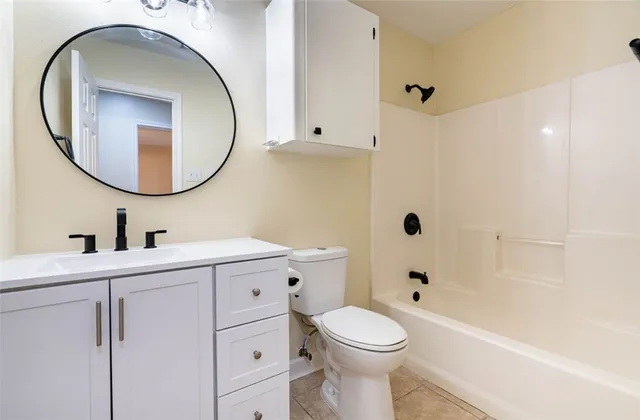 a bathroom with a toilet a sink a mirror and bathtub