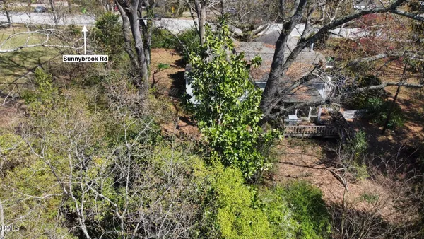 a view of a house with a lush green forest