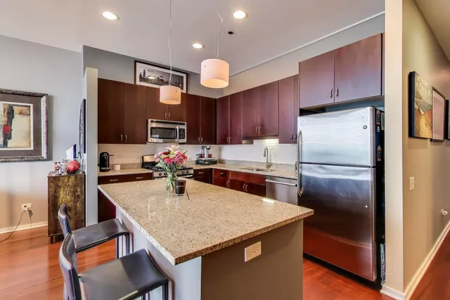 a kitchen with stainless steel appliances granite countertop a sink stove and refrigerator