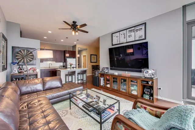 a living room with furniture kitchen view and a wooden floor