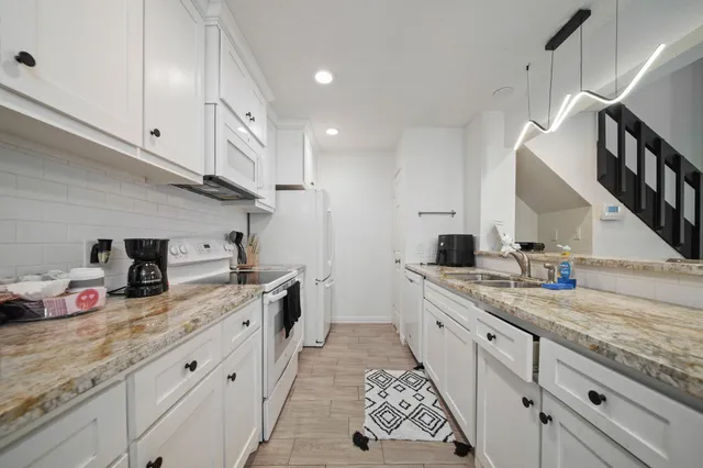 a kitchen with furniture wooden floor and white appliances