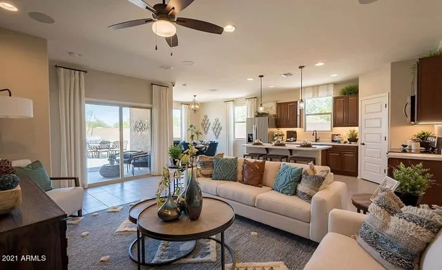 a living room with furniture kitchen view and a chandelier