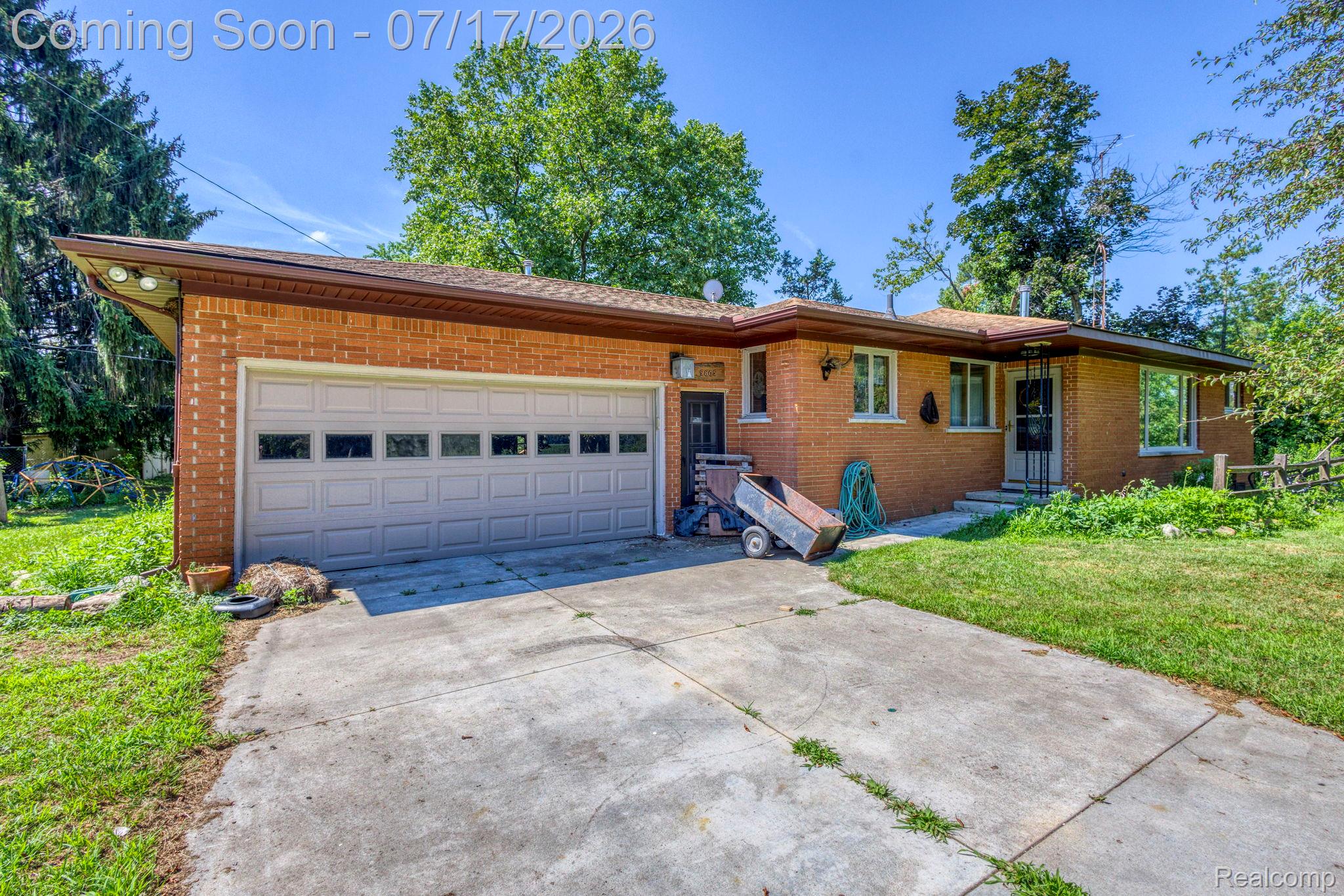9805 Dolan Road Columbus, MI 48063 - Photo 38 of 39 Brick exterior with a concrete driveway leading to an attached two-car garage
