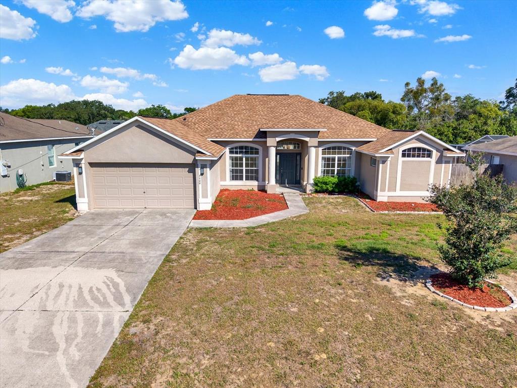 4400 Dior Road Spring Hill, FL 34609 - Photo 2 of 37 a front view of a house with a yard and garage