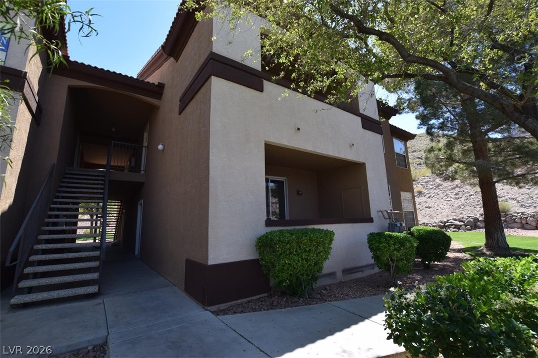 View of side of home featuring stucco siding and a balcony