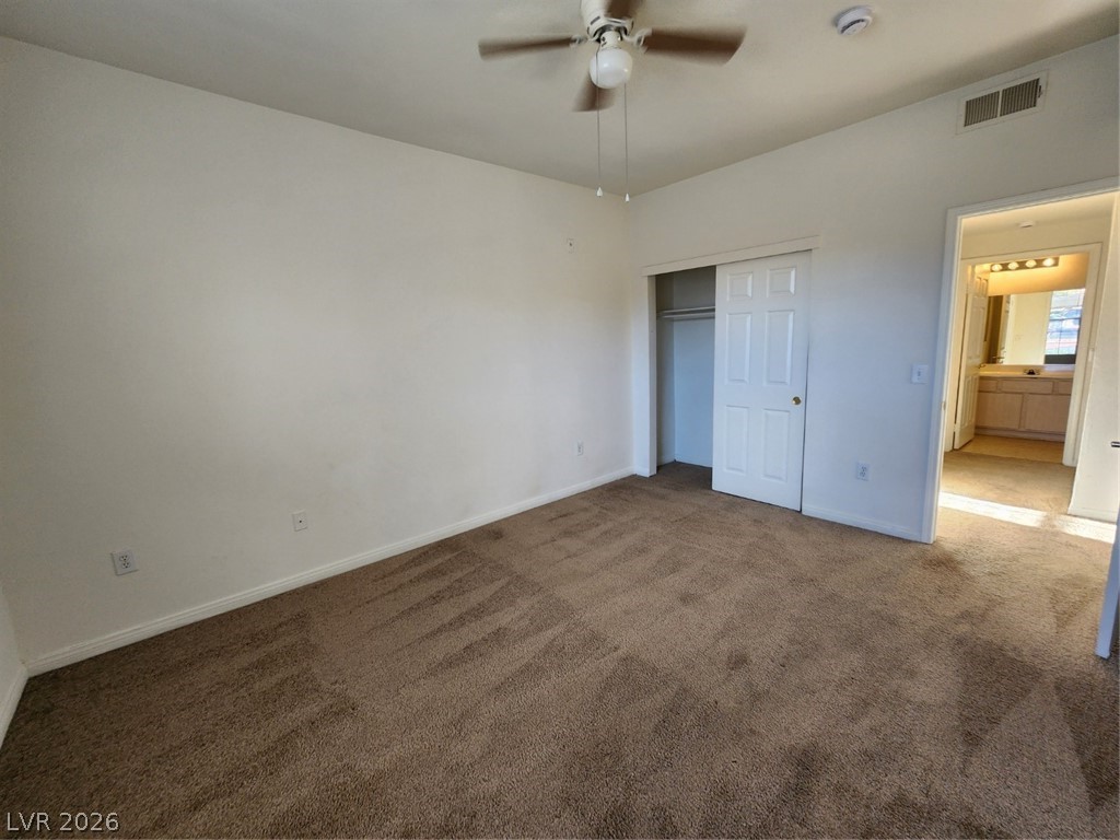 231 West Horizon Ridge Parkway, Unit 417 Henderson, NV 89012 - Photo 23 of 39 Unfurnished bedroom featuring dark colored carpet, a closet, and ceiling fan