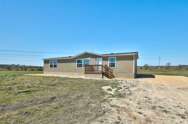 a living room with lots of furniture and kitchen view