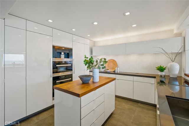 a kitchen with stainless steel appliances granite countertop a sink and a refrigerator