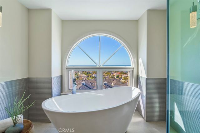 a white bath tub sitting in a bathroom next to a window