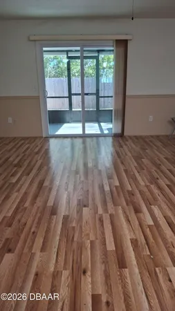 an empty room with wooden floor and cabinets