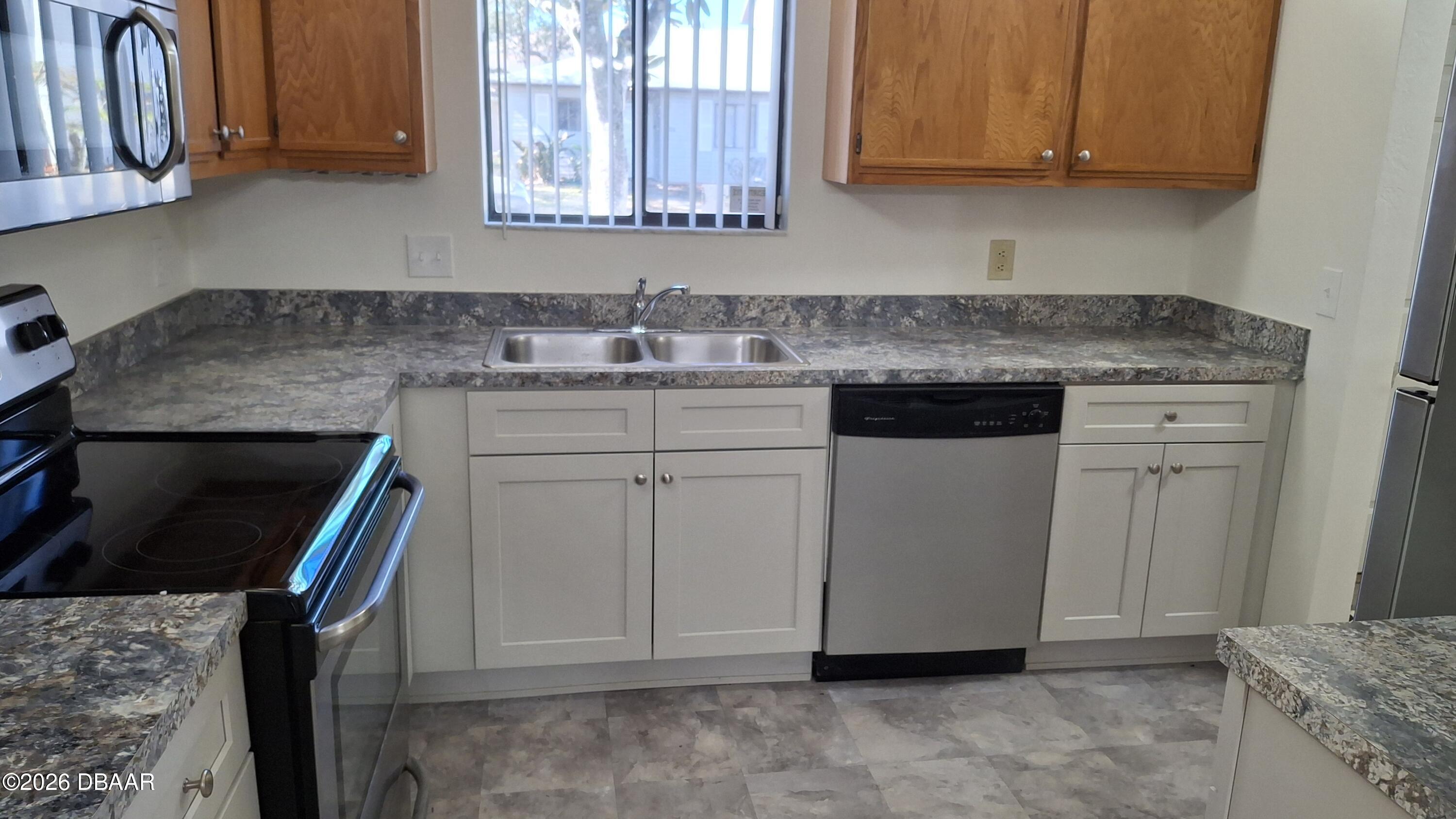1302 Deer Springs Road Port Orange, FL 32129 - Photo 3 of 43 a kitchen with stainless steel appliances granite countertop a sink stove and cabinets