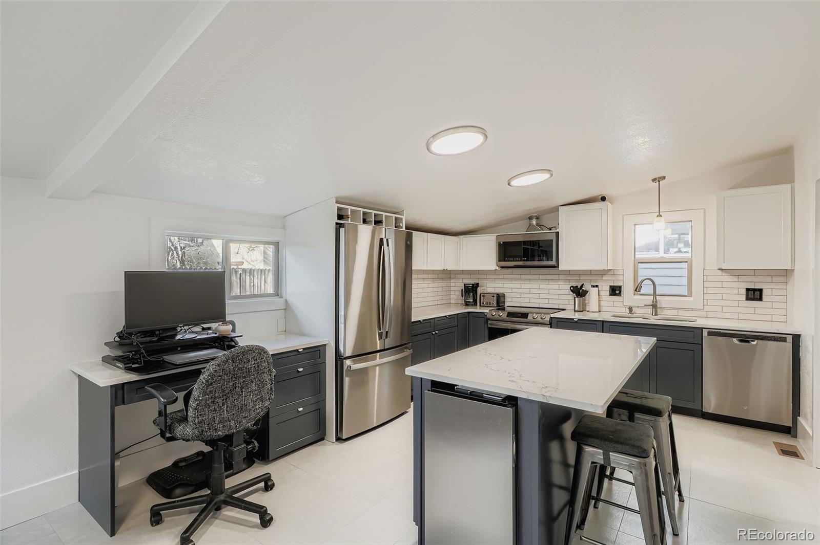 3531 Quitman Street Denver, CO 80212 - Photo 11 of 26 a kitchen with a refrigerator a stove a sink and chairs
