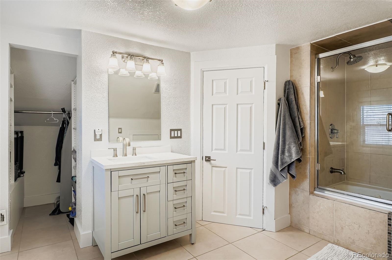 3531 Quitman Street Denver, CO 80212 - Photo 17 of 26 a bathroom with a sink a mirror and a shower