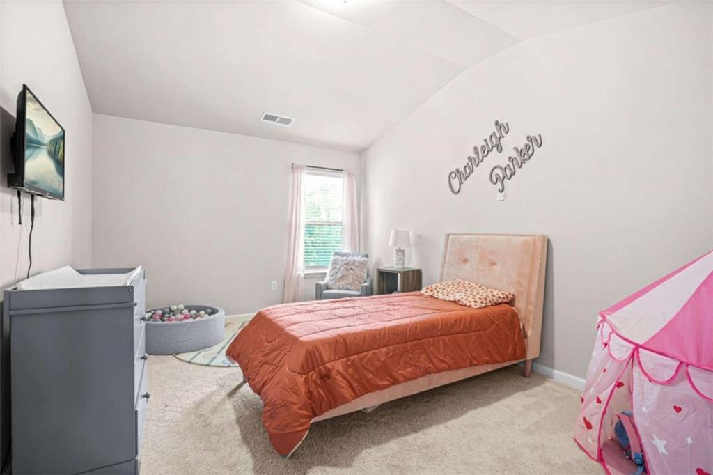 361 Traditions Lane Hampton, GA 30228 - Photo 27 of 35 a bedroom with a bed and a flat screen tv