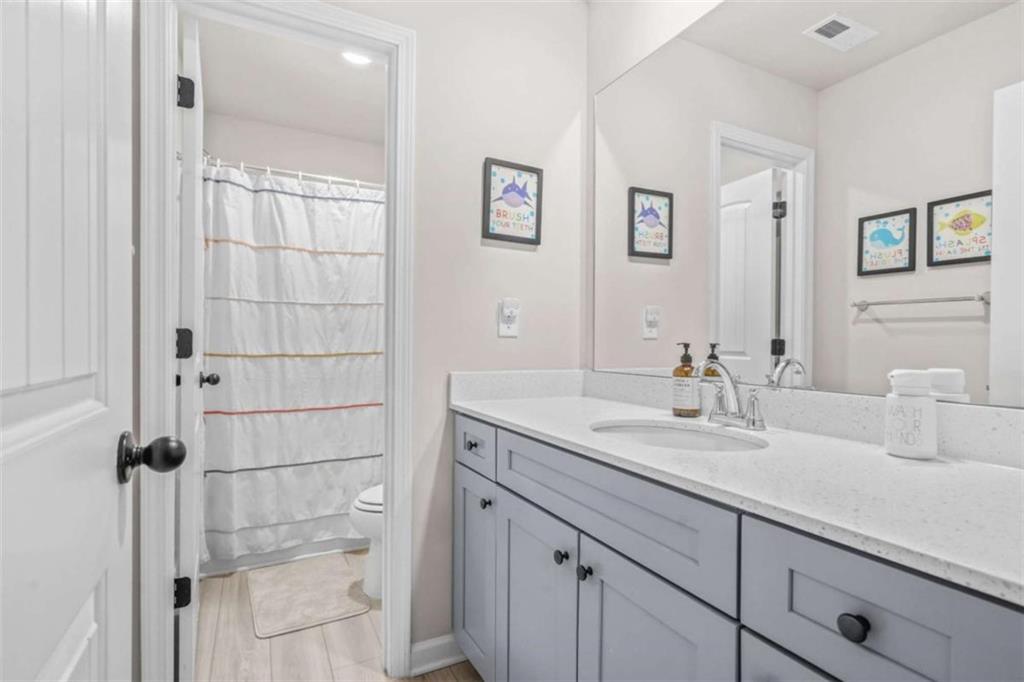 361 Traditions Lane Hampton, GA 30228 - Photo 28 of 35 a bathroom with a granite countertop sink a mirror and shower