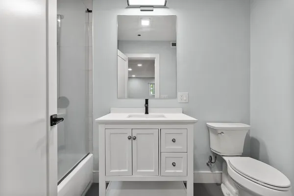 a bathroom with a toilet a sink and mirror