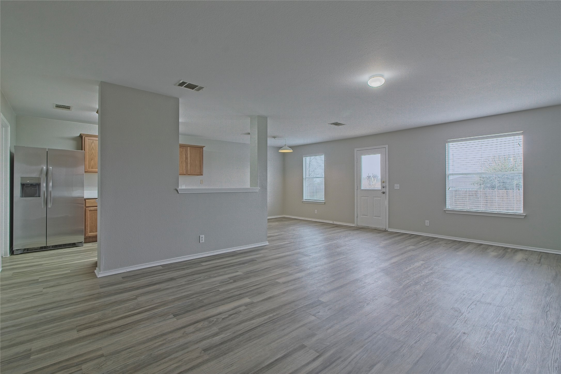 232 Brickyard Lane Jarrell, TX 76537 - Photo 8 of 31 Laminate flooring connects the open concept kitchen with the spacious, naturally illuminated living area.