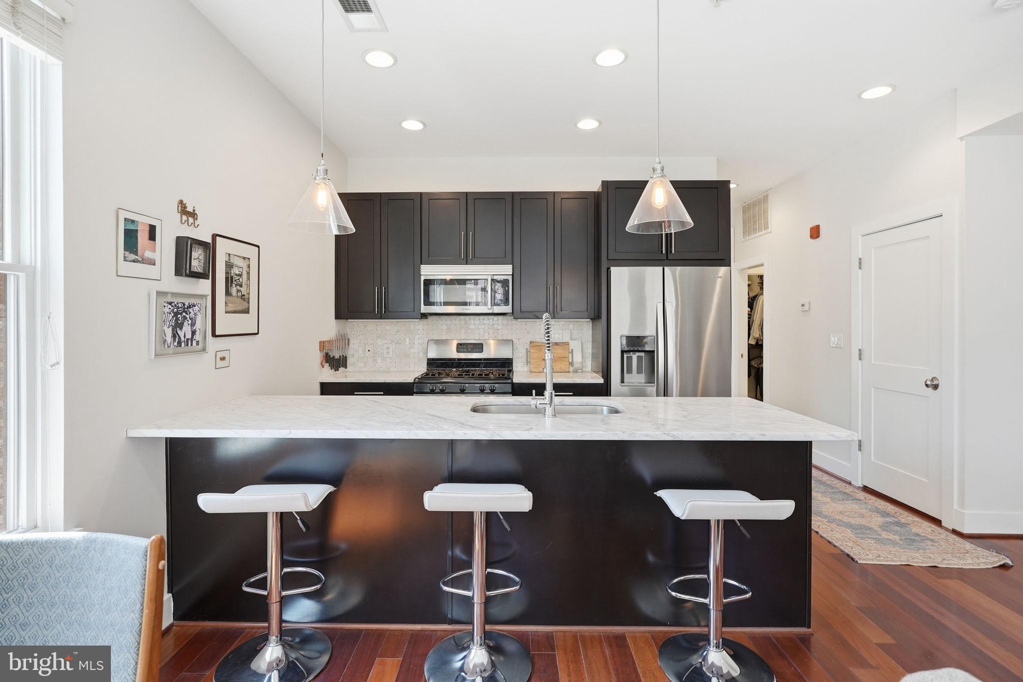 1700 Euclid Street Northwest, Unit B3 Washington, DC 20009 - Photo 6 of 17 a kitchen with stainless steel appliances granite countertop a sink a stove a refrigerator and cabinets