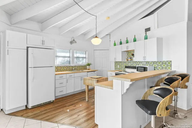 a kitchen with refrigerator and cabinets
