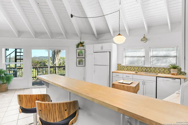a living room with stainless steel appliances kitchen island granite countertop furniture and a large window