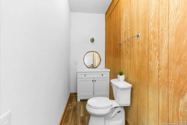 a bathroom with a granite countertop toilet and a sink