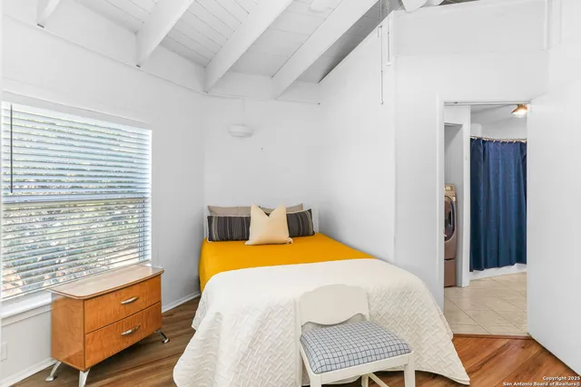 a bedroom with a bed and wooden floor