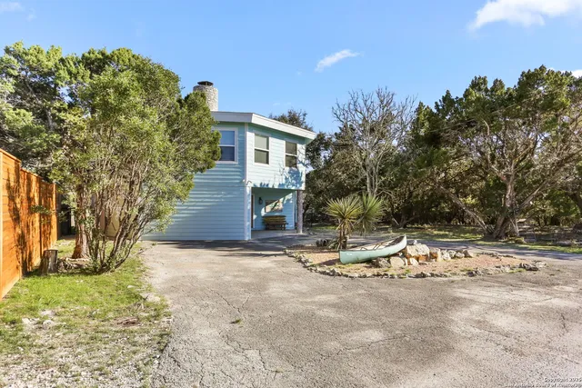 a view of a house with backyard and tree