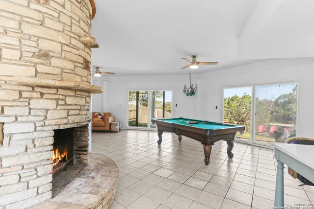 a room with pool table and windows