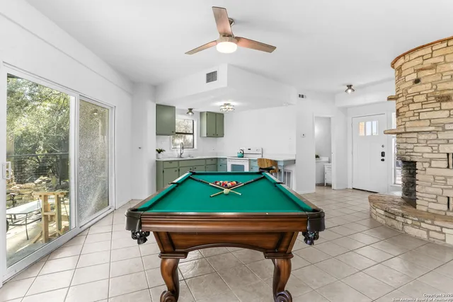 a room with pool table and windows