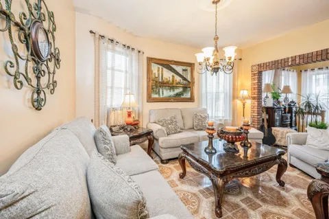 a living room with furniture and a chandelier