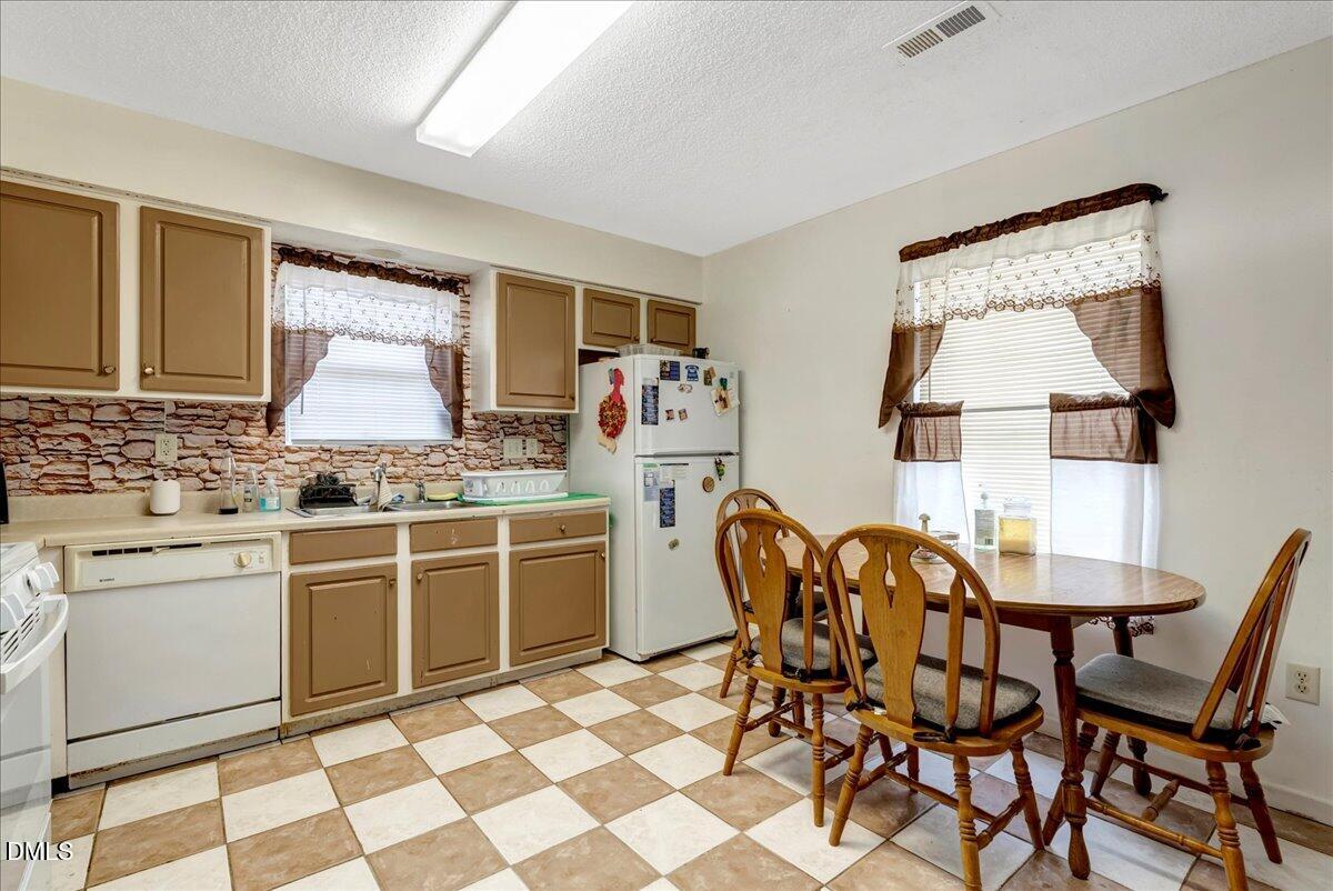 656 No Bottom Road Warrenton, NC 27589 - Photo 18 of 26 a kitchen with a dining table chairs and white appliances