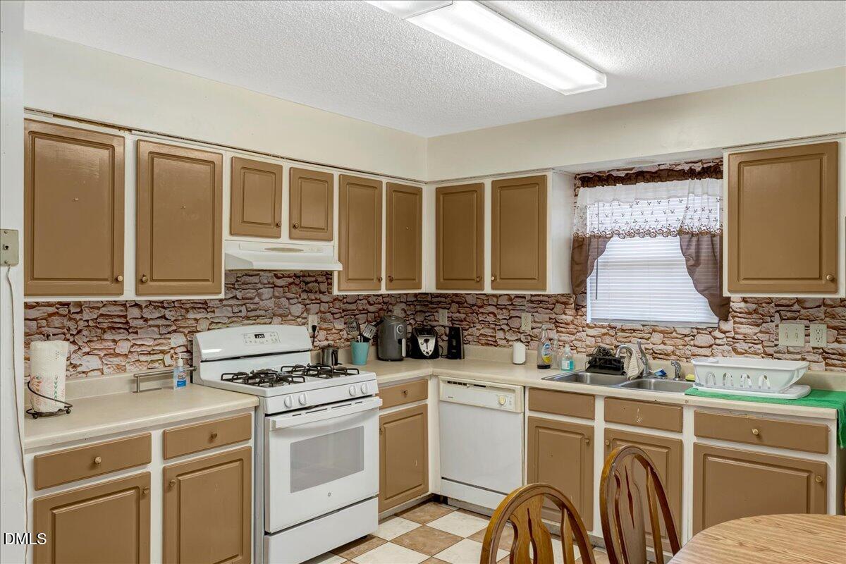 656 No Bottom Road Warrenton, NC 27589 - Photo 19 of 26 a kitchen with a stove a sink and a microwave