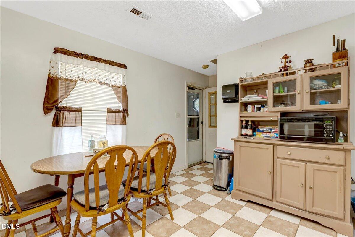 656 No Bottom Road Warrenton, NC 27589 - Photo 20 of 26 a kitchen with a dining table chairs and white cabinets