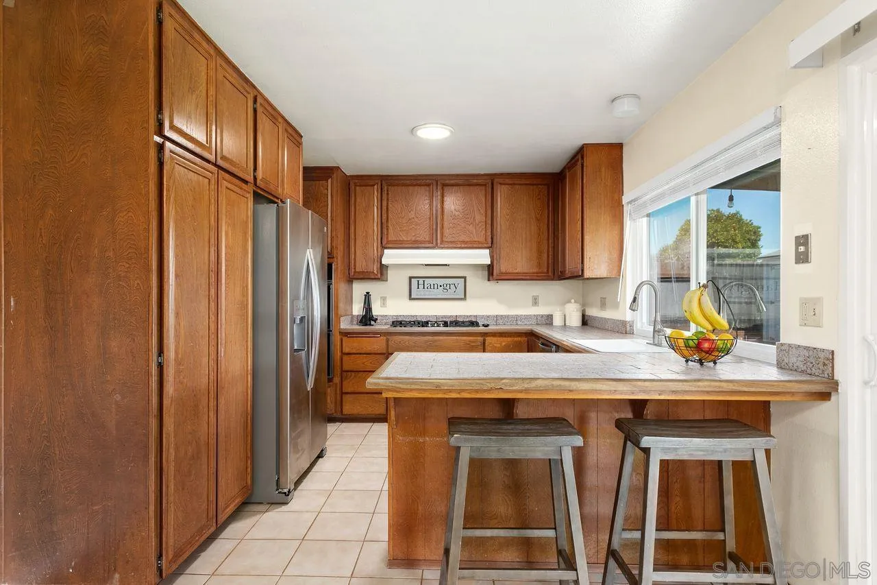 12805 Pinefield Road Poway, CA 92064 - Photo 7 of 31 a kitchen with a refrigerator a sink and cabinets