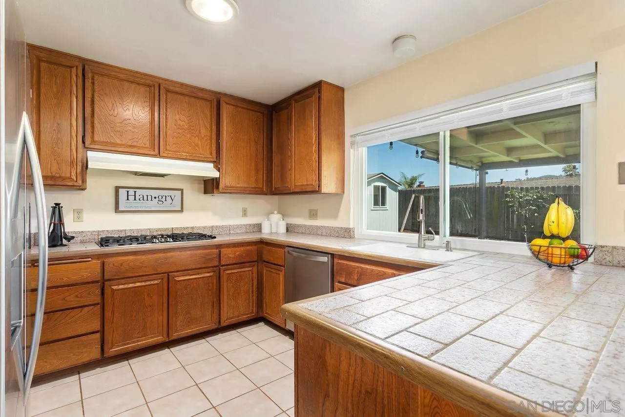 12805 Pinefield Road Poway, CA 92064 - Photo 9 of 31 a kitchen with stainless steel appliances granite countertop a sink and cabinets