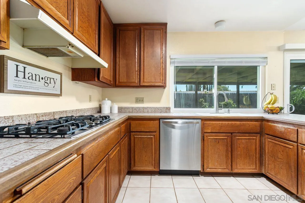 12805 Pinefield Road Poway, CA 92064 - Photo 10 of 31 a kitchen with granite countertop a stove sink and cabinets