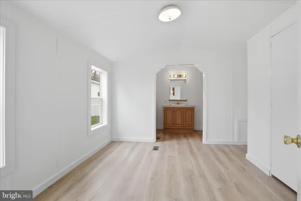 a view of a room with wooden floor a sink and windows