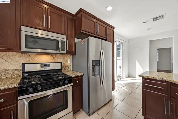 a kitchen with granite countertop a stove and a sink