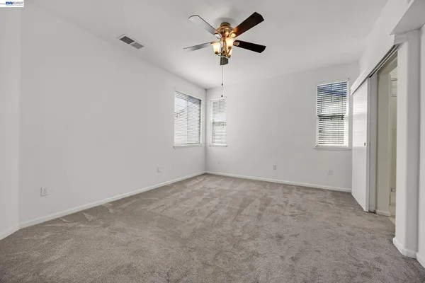a view of empty room with ceiling fan