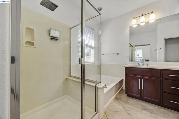 a spacious bathroom with a bathtub sink and mirror
