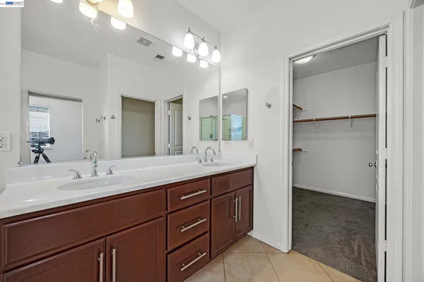 a bathroom with a double vanity sink and a mirror