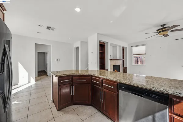 a kitchen with granite countertop wooden cabinets and stainless steel appliances