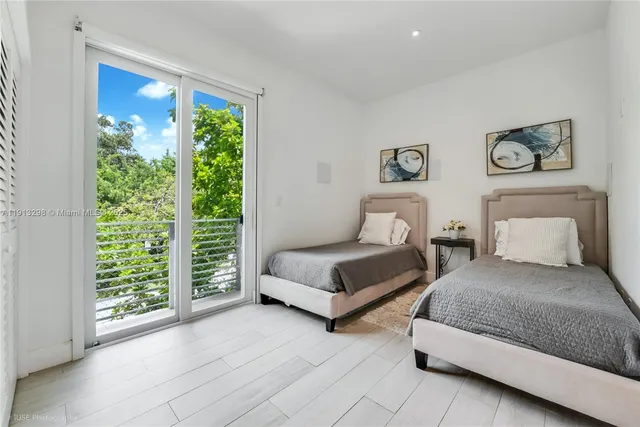 a bedroom with two beds and a large window
