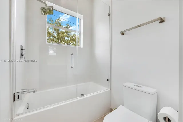 a white bath tub with a toilet and a shower