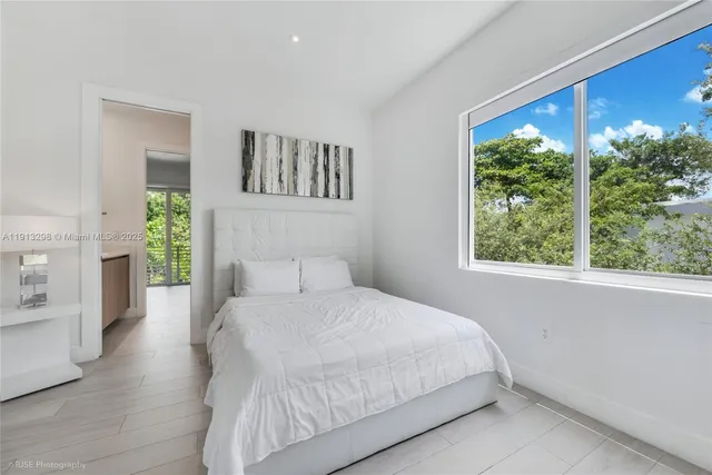 a bedroom with a large bed and a window
